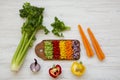 Chopped fresh vegetables carrot, celery, onion, colored peppers arranged on cutting board on a white wooden background, top view Royalty Free Stock Photo