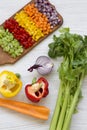 Chopped fresh vegetables arranged on cutting board on white wooden table, high angle view. Royalty Free Stock Photo