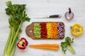 Chopped fresh vegetables arranged on cutting board on white wooden table, overhead view. From above, top view, flat lay. Royalty Free Stock Photo