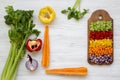 Chopped fresh vegetables arranged on cutting board on white wooden table, top view. From above, overhead, flat lay. Space for text Royalty Free Stock Photo