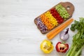 Chopped fresh vegetables arranged on cutting board on white wooden table, overhead view. Flat lay, from above, top view. Copy spa Royalty Free Stock Photo