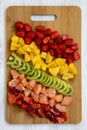 Chopped fruits arranged on cutting board on white wooden background, top view. Ingredients for fruit salad. From above, flat lay, Royalty Free Stock Photo