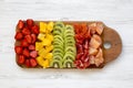 Chopped fruits arranged on cutting board on white wooden background, top view. Ingredients for fruit salad. From above, flat, Royalty Free Stock Photo