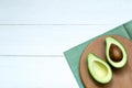 Chopped halves of avocado on a white wooden board, concept background, top view, copy space Royalty Free Stock Photo