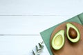 Chopped halves of avocado on a white wooden board, concept background, top view, copy space Royalty Free Stock Photo