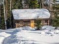 Chopped log house of lumberjacks and builders covered with snow in a winter forest in Altai, Russia Royalty Free Stock Photo