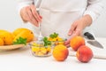 Chopped mangoes and peaches in a glass bowls with mint leaves close up on kitchen table. Royalty Free Stock Photo