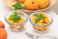 Chopped mangoes and peaches in a glass bowls with mint leaves close up on kitchen table. Royalty Free Stock Photo