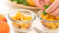 Chopped mangoes and peaches in a glass bowls with mint leaves close up on kitchen table. Royalty Free Stock Photo