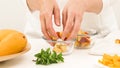 Chopped mangoes and peaches in a glass bowls, woman hands, white background. Fresh fruit salad Royalty Free Stock Photo