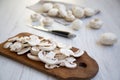 Chopped mushrooms on rustic wooden chopping board, closeup. White wooden background. Royalty Free Stock Photo