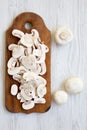 Chopped mushrooms on wooden chopping board, view from above. White wooden background. Overhead Royalty Free Stock Photo