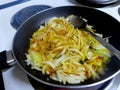 Chopped onions frying in a frying pan on a the stove with a bit of oil and some spices. Royalty Free Stock Photo