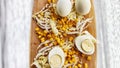 Chopped Peking cabbage, peeled eggs and yellow canned corn on cutting board as a background. Cooking a healthy eco