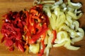 chopped pieces of green and red bell pepper on a wooden cutting board Royalty Free Stock Photo