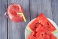 Chopped pieces of watermelon on a white plate and a glass mug with a watermelon smoothie Royalty Free Stock Photo