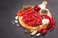 Chopped raw beef or lamb meat with seasoning and vegetables on the round wooden serving plate Royalty Free Stock Photo