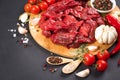 Chopped raw beef or lamb meat with spices, seasoning, chili pepper and tomatoes over dark concrete background Royalty Free Stock Photo
