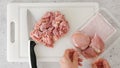 Chopped raw chicken fillet close-up on a white plastic cutting board. The chef cuts meat, close-up preparation process, recipe Royalty Free Stock Photo