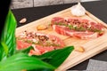 Chopped raw pork steaks with spices, garlic and thyme on a cutting kitchen board on a black wooden table Royalty Free Stock Photo