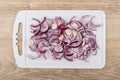 Chopped red onion on cutting board on wooden table Royalty Free Stock Photo