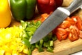 Chopped red and yellow green peppers with cutting knife on wood. gastronomy concept Royalty Free Stock Photo