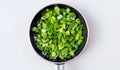 Chopped spring onions or chives isolated in frying pan on white background, top view Royalty Free Stock Photo