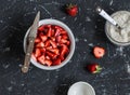 Chopped strawberries and the jar with whole grain flour on a dark background. Ingredients for making strawberry pie Royalty Free Stock Photo