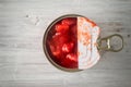 Chopped tomatoes in the metal can in the white wooden table top view