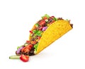 Chopped toppings spilling out of a Mexican taco isolated on a white background