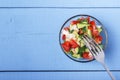 Chopped vegetables - cucumbers, tomatoes and onions in glass bowl on wooden table. View from above. Copy space Royalty Free Stock Photo