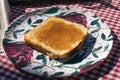 Chopped view of a plate with a toast spread with peach jam Royalty Free Stock Photo