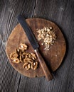 Chopped walnuts and knife on wooden plate