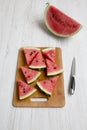 Chopped watermelon on bamboo board over white wooden background, high angle. Royalty Free Stock Photo