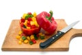 Chopped yellow, red and green peppers and a kitchen knife on a wooden board Royalty Free Stock Photo