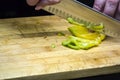 Chopped yellow, red and green peppers and a kitchen knife on a wooden board  on white background Royalty Free Stock Photo