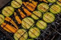 Chopped zucchini and carrots roasting on fire seasoned with aroma herbs and spices. Delicious fresh vegetables grilling Royalty Free Stock Photo