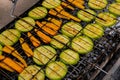 Chopped zucchini and carrots roasting on fire seasoned with aroma herbs and spices. Delicious fresh vegetables grilling Royalty Free Stock Photo