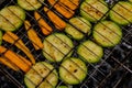 Chopped zucchini and carrots roasting on fire seasoned with aroma herbs and spices. Delicious fresh vegetables grilling Royalty Free Stock Photo