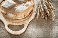 Chopping board bread rye ears on burlap background Royalty Free Stock Photo