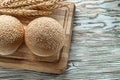 Chopping board bread rye ears on wooden surface Royalty Free Stock Photo