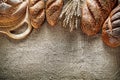 Chopping board brown bread baguette wheat ears on burlap backgro