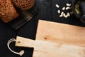 Chopping board and various crusty whole wheat bread on black woo