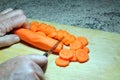 Chopping carrots on a wooden board. Royalty Free Stock Photo