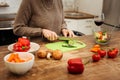 Focused fit mature woman cutting vegetables for healthy salad