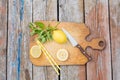 Chopping cutting board, sliced lemon, mint leaves, knife and straw on wooden table. Cocktail preparation. Summer. Top Royalty Free Stock Photo