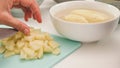 Chopping potatoes on chopping board close up on white kitchen table Royalty Free Stock Photo