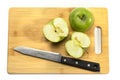 chopping wooden board, on it are green apples and a knife, one apple is cut into two parts Royalty Free Stock Photo
