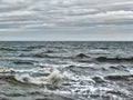 Choppy atlantic ocean waves with surf and grey winter clouds