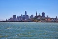 Choppy San Francisco Bay water with distant downtown skyscrapers and piers with ships docked